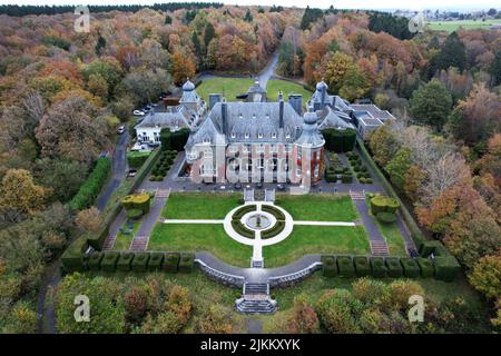 Une vue aérienne de l'hôtel Manoir de Lebioles en Belgique entouré d'arbres denses en automne Banque D'Images