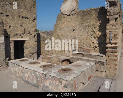 Restaurant-snack romain conservé avec comptoir en marbre et grands pots en argile à Herculanum ou Ercolano Scavi, Campanie, Italie Banque D'Images