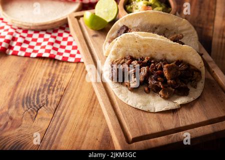 Tacos de Bistec. Viande grillée maison dans une tortilla au maïs. Cuisine de rue du Mexique, traditionnellement accompagnée de coriandre, d'oignon et de sauce épicée ou Banque D'Images