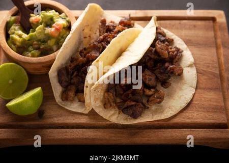 Tacos de Bistec. Viande grillée maison dans une tortilla au maïs. Cuisine de rue du Mexique, traditionnellement accompagnée de coriandre, d'oignon et de sauce épicée ou Banque D'Images