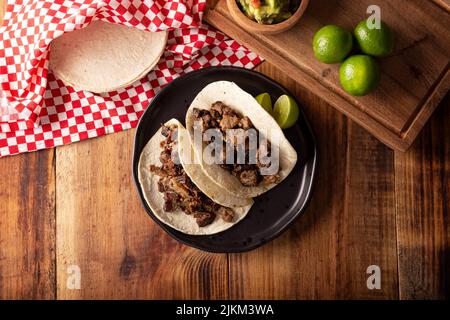 Tacos de Bistec. Viande grillée maison dans une tortilla au maïs. Cuisine de rue du Mexique, traditionnellement accompagnée de coriandre, d'oignon et de sauce épicée ou Banque D'Images