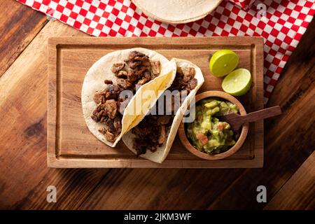 Tacos de Bistec. Viande grillée maison dans une tortilla au maïs. Cuisine de rue du Mexique, traditionnellement accompagnée de coriandre, d'oignon et de sauce épicée ou Banque D'Images