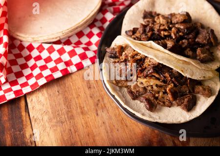 Tacos de Bistec. Viande grillée maison dans une tortilla au maïs. Cuisine de rue du Mexique, traditionnellement accompagnée de coriandre, d'oignon et de sauce épicée ou Banque D'Images