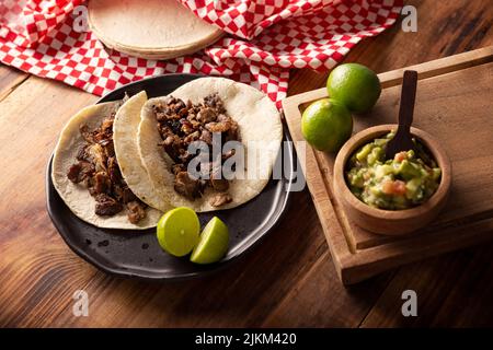 Tacos de Bistec. Viande grillée maison dans une tortilla au maïs. Cuisine de rue du Mexique, traditionnellement accompagnée de coriandre, d'oignon et de sauce épicée ou Banque D'Images