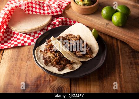 Tacos de Bistec. Viande grillée maison dans une tortilla au maïs. Cuisine de rue du Mexique, traditionnellement accompagnée de coriandre, d'oignon et de sauce épicée ou Banque D'Images