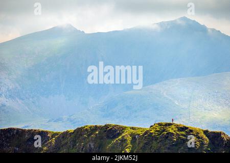 Un marcheur sur la crête de Nantlle, une promenade sur les crêtes de montagne à Snowdonia, au nord du pays de Galles, au Royaume-Uni. Snowdon est le sommet de la distance Banque D'Images