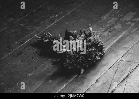 Un bouquet de fleurs sauvages se trouve sur le sol de la maison photo noir et blanc, fleurs sur le sol Banque D'Images