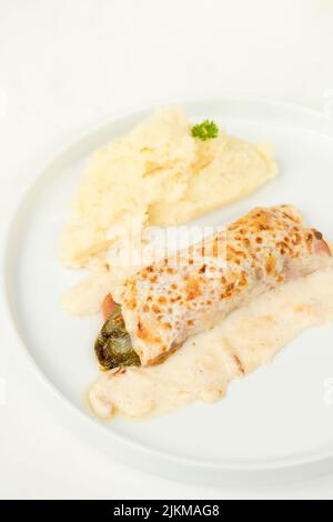 A vertical shot of a Belgian classic dish called Chicon gratin served on a white plate Banque D'Images