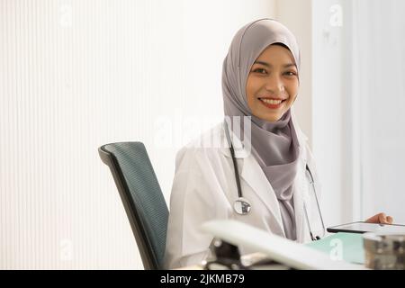 Une femme médecin d'Asie du Sud-est assise dans son cabinet Banque D'Images