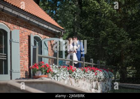 Un heureux couple de jeunes mariés du Caucase debout sur un balcon Banque D'Images