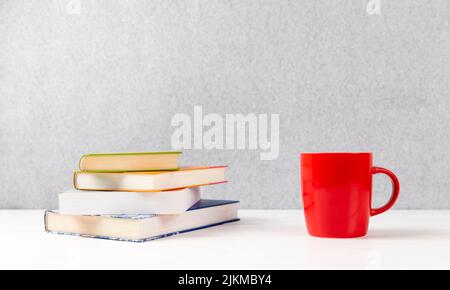 livres avec coupe rouge sur une table avec fond gris et espace de copie Banque D'Images
