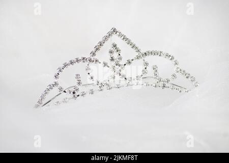 A closeup of a silver crown with gemstones on a white background Stock Photo