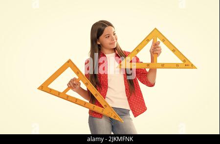 heureux enfant tenir un triangle dirigeant étudier les mathématiques à l'école isolée sur blanc, de retour à l'école Banque D'Images