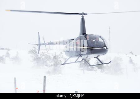 A Landing black Helicopter on a snowy mountain in Lapland, Finland Stock Photo