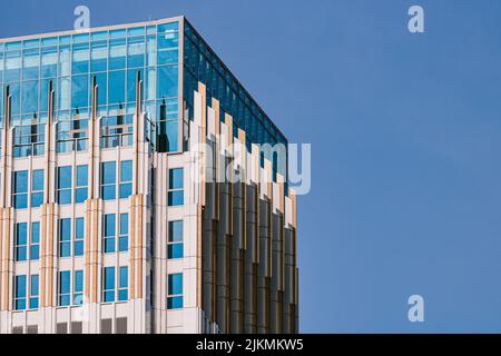 Vue extérieure d'un bâtiment moderne avec fenêtres en verre sur fond bleu ciel Banque D'Images