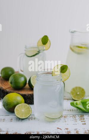 Pot de verre de limonade avec citrons verts ou citron vert sur fond blanc en Amérique latine Banque D'Images