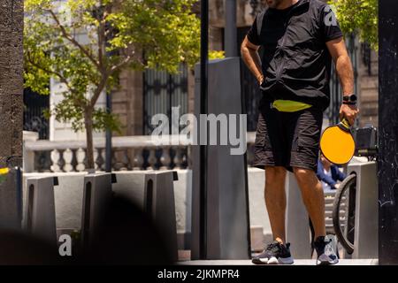 jeune homme, gramode jouant au paddle-tennis dans la rue Banque D'Images