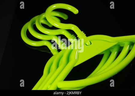 A group of green plastic hangers on black background Banque D'Images