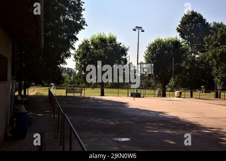 Terrain de basket-ball vide bordé d'un rail par une journée ensoleillée Banque D'Images