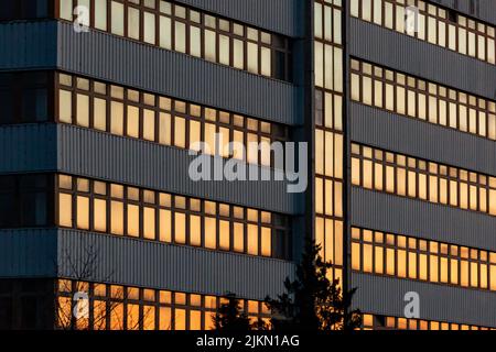 A closeup of a modern building pattern with the evening sky reflected on the windows Banque D'Images
