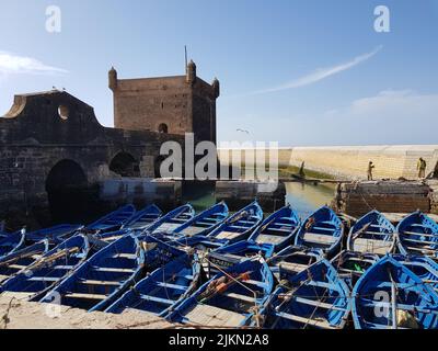 Petit bateau de pêche en bois bleu vif, stationné dans la baie entre vente  et Rabat. L'eau de l'océan calme reflétant le bateau. Rabat - Vente, Maroc  Photo Stock - Alamy