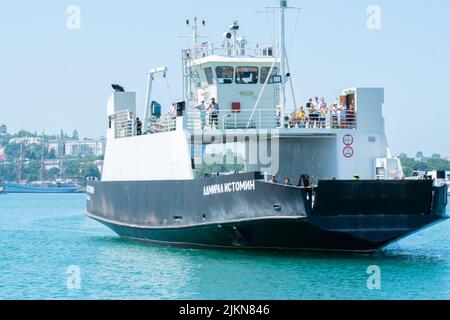 RUSSIE, CRIMÉE - JUL 08, 2022: Sébastopol crimée mer baie russie ville jetée ferry navire ciel, concept tourisme noir dans le transport pour le bord de mer en plein air Banque D'Images