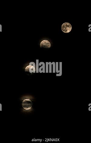 The vertical shot of phases of a moon on a black background Banque D'Images