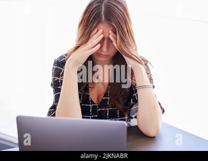 Je le souligne aujourd'hui. Une jeune femme d'affaires assise devant son ordinateur portable en détresse. Banque D'Images