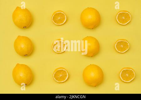 Vue sur le sommet du citron avec demi-citron et citrons entiers mûrs sur fond jaune Banque D'Images