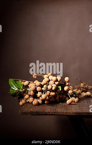 Un cliché sélectif de fruits frais de Longan sur une table en bois Banque D'Images