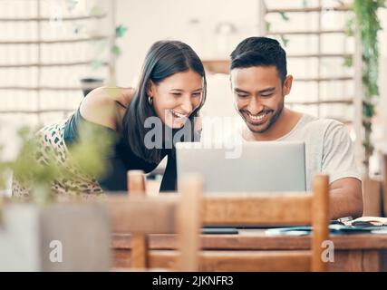 Couple heureux, riant et décontracté regardant ou regardant une vidéo amusante sur un ordinateur portable ensemble dans un restaurant pendant la journée. Petit ami et Banque D'Images
