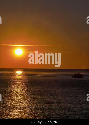 A bright sunset scene with the sun shining brightly over the sea Banque D'Images