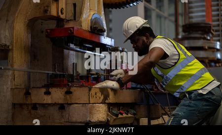 Industrie lourde Foreman Ingénieur sécurité blouson sécurité entretien préventif quotidien vérifier machine dans l'usine de fabrication, utiliser presse-papiers, avoir discussion Banque D'Images