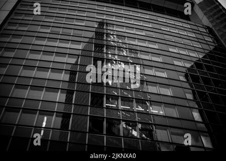 A low angle grayscale shot of a reflective modern building in Frankfurt, Germany Stock Photo