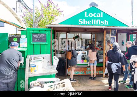 Oban Resort ville et quai, cabane verte vendant des fruits de mer frais et des coquillages aux clients, Oban, Argyll, Écosse le soleil été jour 2022 Banque D'Images