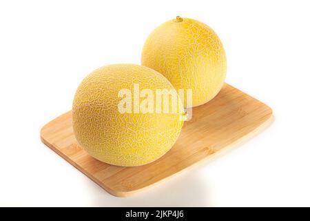 Les melons sur un panneau en bois isolé sur un fond blanc Banque D'Images