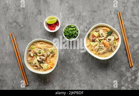 Deux bols de curry laksa, plat de nouilles en verre épicé populaire en Asie du Sud-est. Banque D'Images