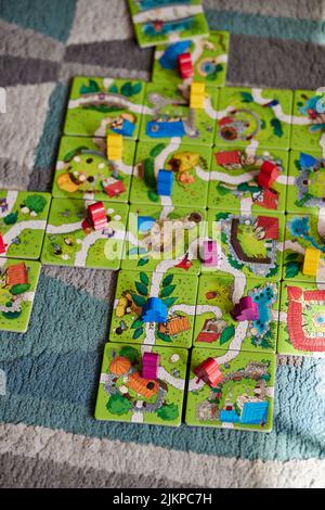 A vertical shot of a Carcassonne Junior game with cards and colorful wooden figurines Stock Photo