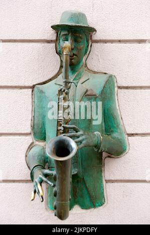 Statue de bronze du saxophoniste traversant le mur à Tbilissi, Géorgie Banque D'Images