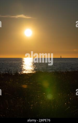 A vertical shot of a yellow sunset over the sea in Trelleborg beach, Sweden Banque D'Images