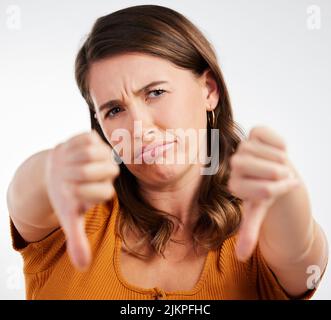 Mon niveau d'énergie aujourd'hui. Photo studio d'une jeune femme montrant les pouces sur fond blanc. Banque D'Images