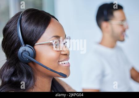 Nous travaillons si bien ensemble. Les membres de l'équipe, hommes et femmes, sont assis à leur bureau dans leur centre d'appels. Banque D'Images