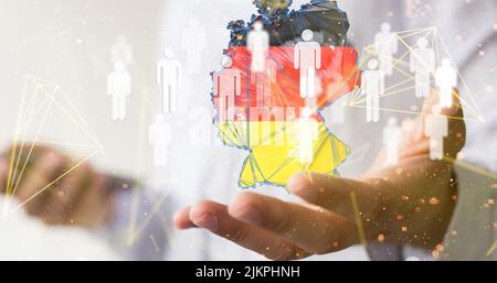 A businessman holding 3D rendered human icons and the German map, a global network concept Stock Photo