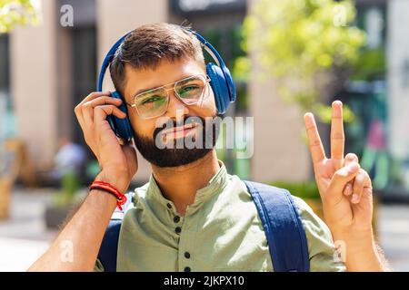 étudiant indien avec un casque bleu et un sac à dos bien regardant la journée ensoleillée Banque D'Images