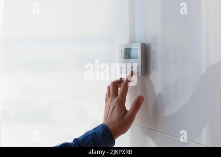 Le panneau de commande de climatisation et de chauffage de l'appartement et du bureau est situé sur un mur blanc. Banque D'Images