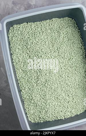 Boîte à litière pour chats avec litière en tofu biodégradable et lavable naturel et parfum de poudre de thé vert. Produit écologique pour animaux domestiques. Vue de dessus, espace de copie Banque D'Images