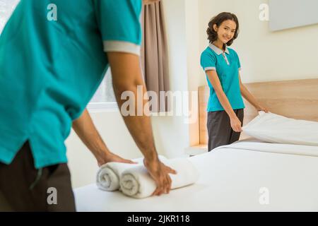 Femme femme souriante dans un lit turquoise uniforme Banque D'Images