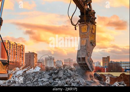 Broyeur de béton travaille avec pile de pierres de ciment de proximité Banque D'Images