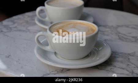 Deux tasses de cappuccino ou de latte décorées de mousse sur fond de table en marbre Banque D'Images