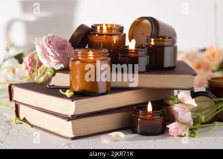 Un ensemble de bougies parfumées dans des pots en verre brun. Bougie parfumée faite à la main. Les bougies de soja brûlent dans un pot. Aromathérapie et détente au spa et à la maison. Faire feu dans un pot brun. Banque D'Images